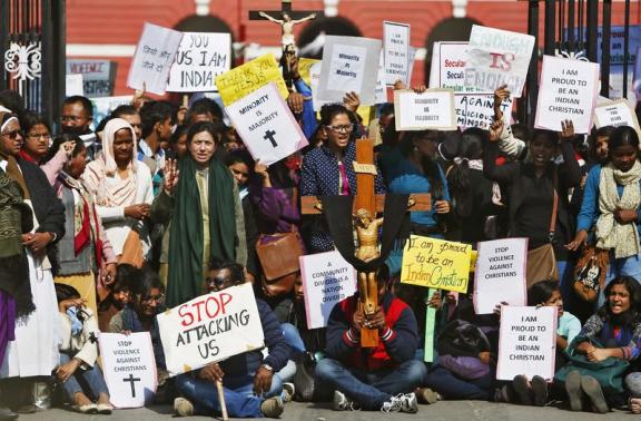 Demonstrators shout slogans as they hold placards during a protest outside a church in New Delhi